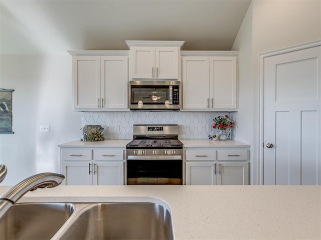 kitchen with decorative backsplash, white cabinetry, and stainless steel appliances