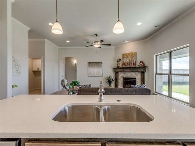 kitchen with crown molding, sink, and pendant lighting