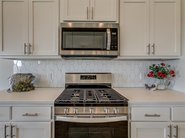 kitchen with decorative backsplash, white cabinetry, and stainless steel appliances