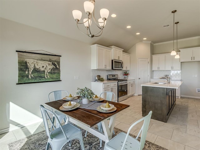 dining space featuring an inviting chandelier, crown molding, sink, vaulted ceiling, and light tile patterned flooring