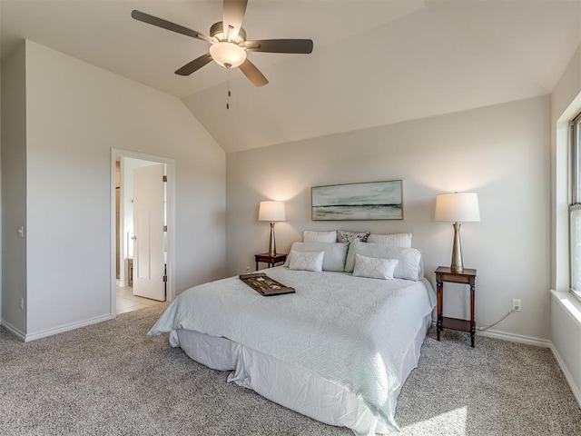 carpeted bedroom featuring ceiling fan, ensuite bathroom, and vaulted ceiling