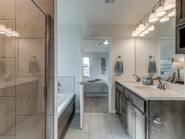 bathroom featuring tile patterned flooring, vanity, a relaxing tiled tub, and ceiling fan