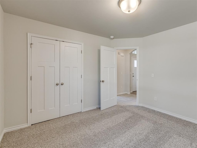 unfurnished bedroom with light carpet and a closet