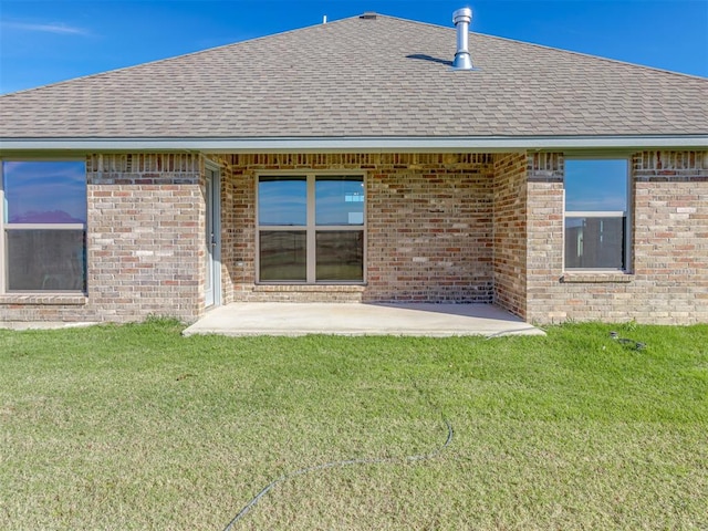 back of property with a yard and a patio