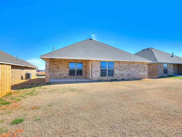 rear view of house featuring a lawn, cooling unit, and a patio