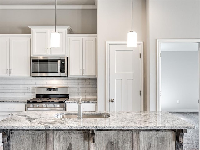 kitchen with white cabinets, stainless steel appliances, and decorative light fixtures