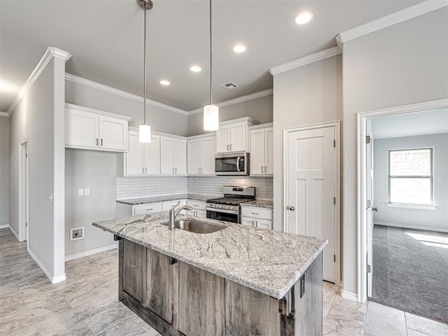 kitchen featuring a center island with sink, white cabinets, sink, and appliances with stainless steel finishes