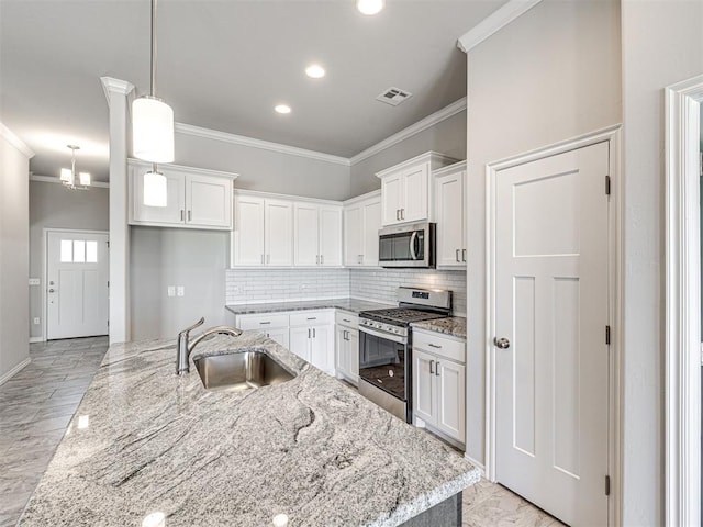 kitchen with stainless steel appliances, white cabinetry, ornamental molding, and sink