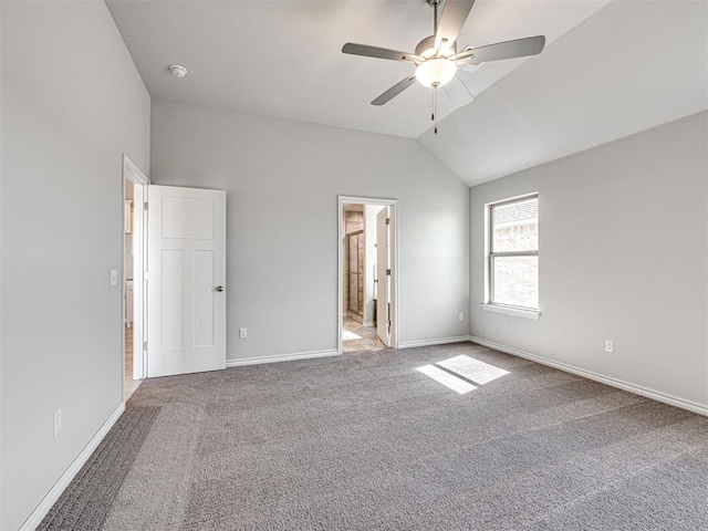 unfurnished bedroom featuring ceiling fan, carpet floors, ensuite bathroom, and vaulted ceiling