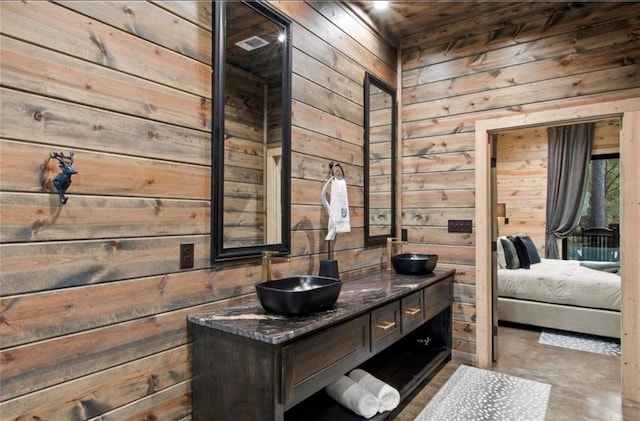 bathroom featuring wood walls, vanity, and concrete floors