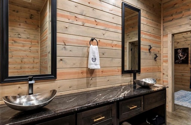 bathroom featuring vanity and wood walls