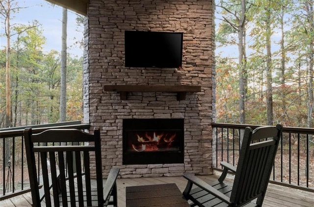 wooden deck featuring an outdoor stone fireplace