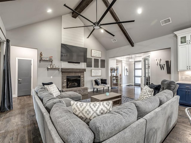 living room featuring dark wood-type flooring, high vaulted ceiling, ceiling fan, a fireplace, and beam ceiling