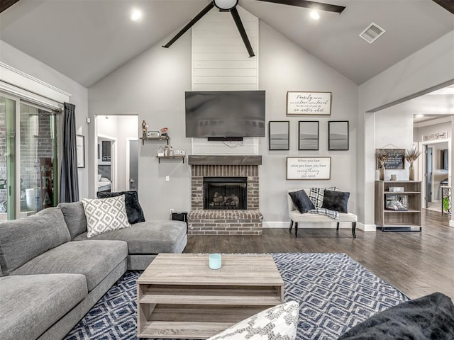 living room featuring a fireplace, dark hardwood / wood-style flooring, and high vaulted ceiling