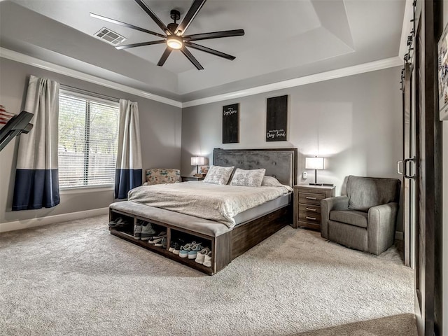 carpeted bedroom with a tray ceiling, ceiling fan, and ornamental molding