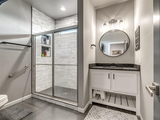 bathroom with tile patterned floors, toilet, vanity, and walk in shower