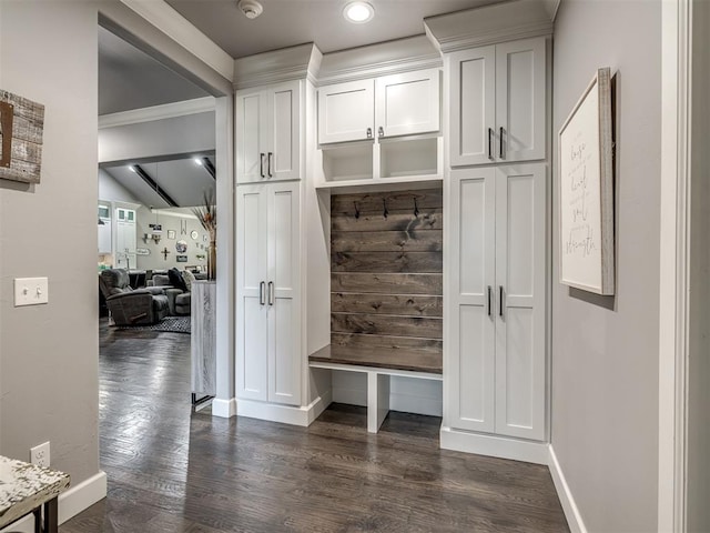 mudroom with ornamental molding, dark wood-type flooring, and beam ceiling