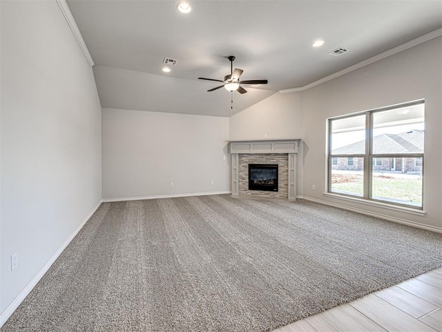 unfurnished living room featuring ceiling fan, a stone fireplace, lofted ceiling, and crown molding