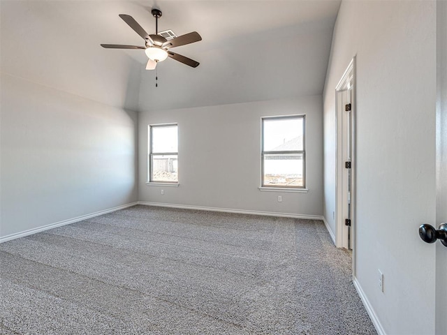 empty room featuring light colored carpet, vaulted ceiling, and ceiling fan