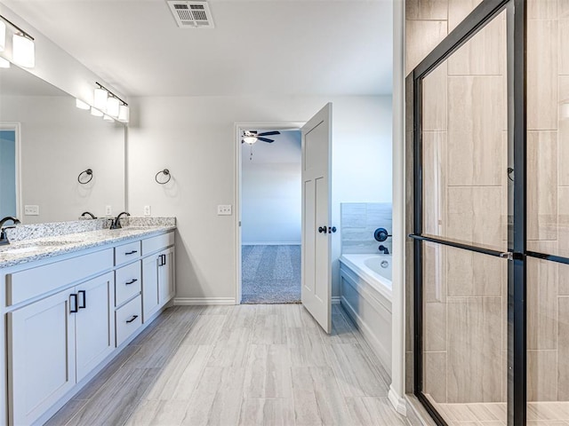 bathroom with ceiling fan, shower with separate bathtub, and vanity