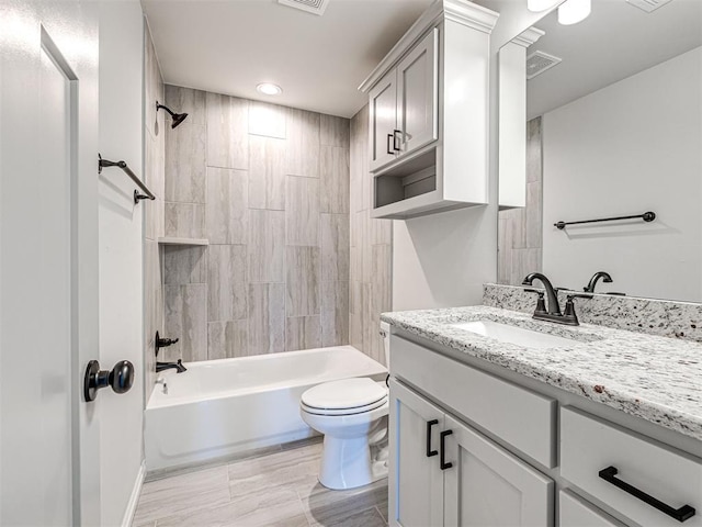 full bathroom with hardwood / wood-style floors, tiled shower / bath combo, toilet, and vanity