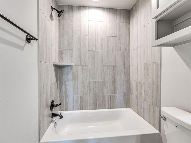 bathroom featuring tiled shower / bath combo and toilet