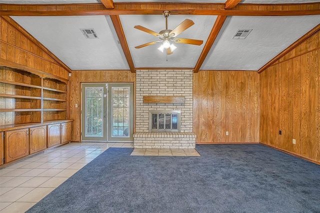 unfurnished living room featuring ceiling fan and wooden walls