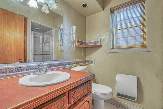 bathroom with tile patterned floors, vanity, toilet, and an enclosed shower