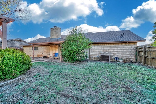 rear view of house with a lawn, central air condition unit, and a patio