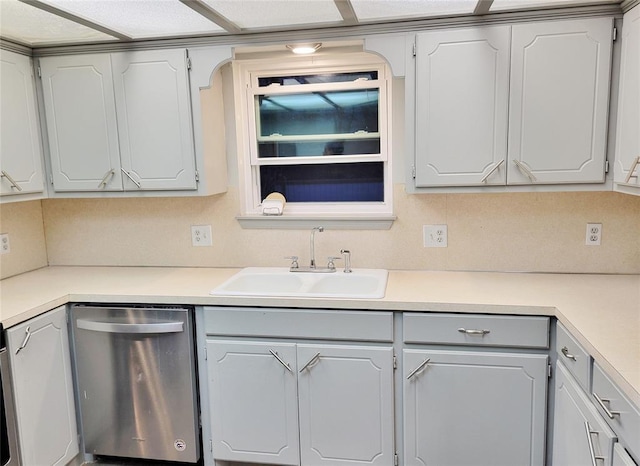 kitchen featuring gray cabinets, decorative backsplash, stainless steel dishwasher, and sink