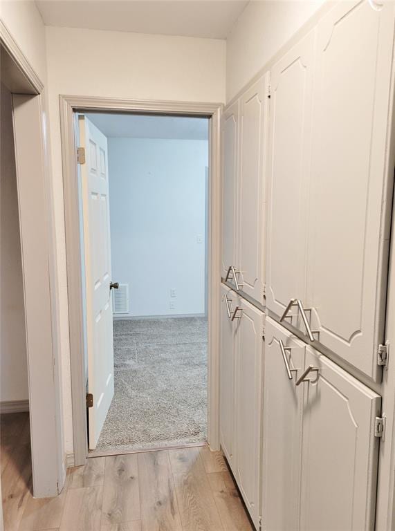 hallway with light hardwood / wood-style floors