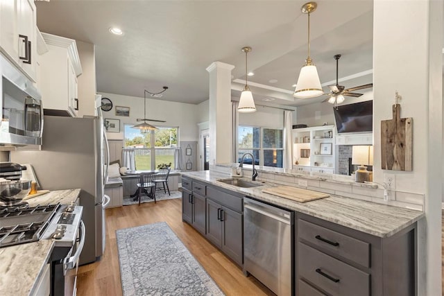 kitchen featuring white cabinetry, appliances with stainless steel finishes, sink, and hanging light fixtures