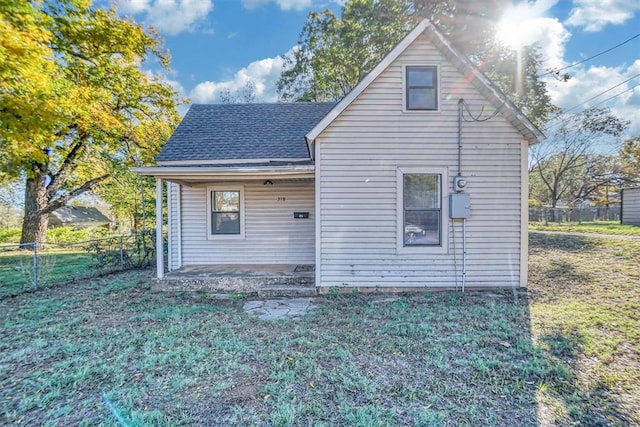 rear view of house featuring a lawn