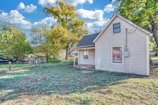 rear view of house featuring a lawn