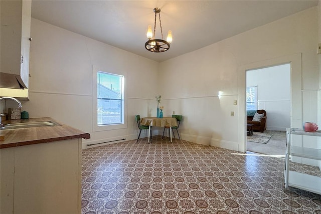 unfurnished dining area with sink and a chandelier