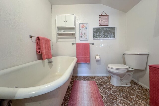 bathroom with toilet, tile patterned flooring, vaulted ceiling, and a bathtub