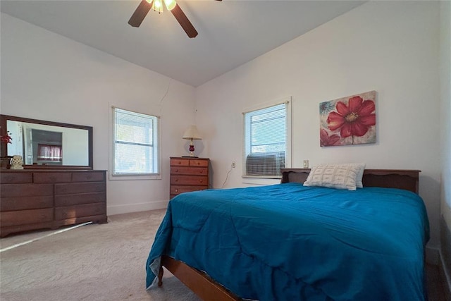 bedroom featuring multiple windows, ceiling fan, light colored carpet, and vaulted ceiling