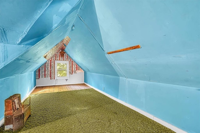 bonus room featuring wood-type flooring and vaulted ceiling