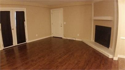 unfurnished living room with dark wood-type flooring