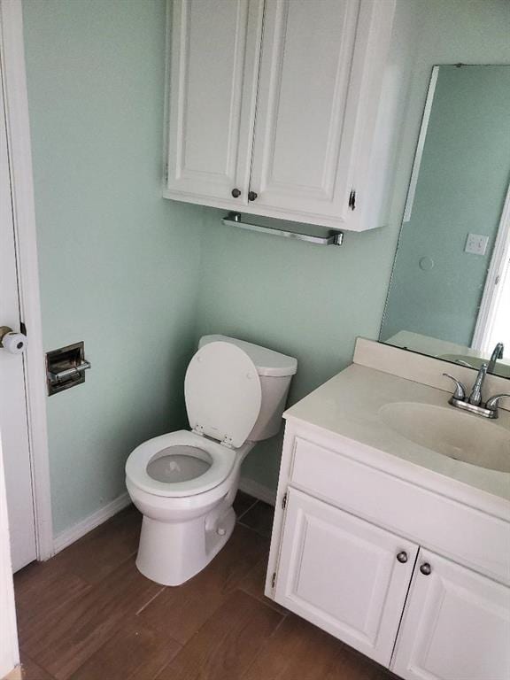 bathroom with toilet, vanity, and hardwood / wood-style flooring