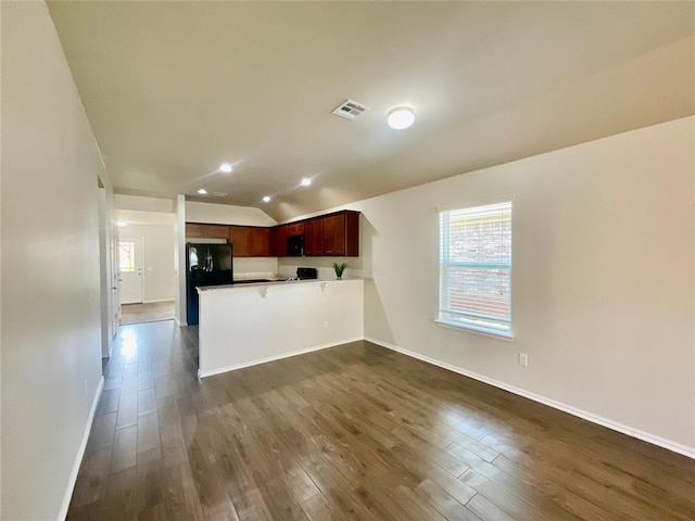 kitchen with black appliances, kitchen peninsula, dark wood-type flooring, and lofted ceiling