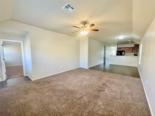 unfurnished living room with dark carpet, ceiling fan, and lofted ceiling