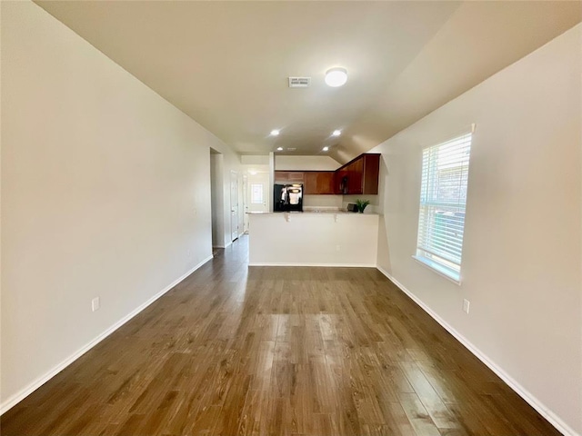 unfurnished living room with dark hardwood / wood-style flooring and vaulted ceiling