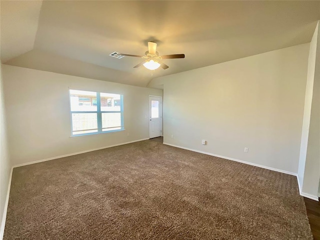 empty room with ceiling fan, dark carpet, and vaulted ceiling