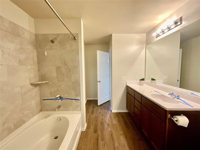 bathroom featuring vanity, wood-type flooring, and tiled shower / bath combo