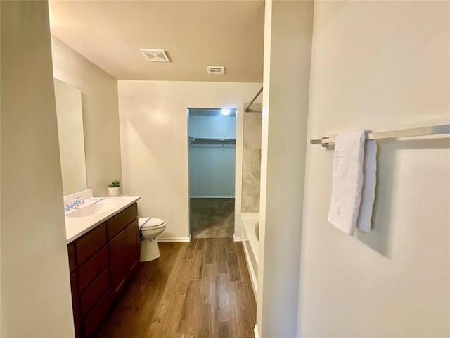 bathroom with toilet, vanity, and hardwood / wood-style flooring