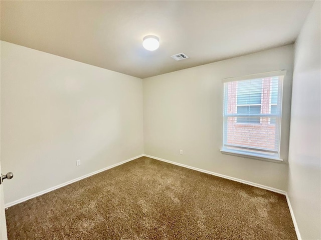 spare room featuring dark carpet