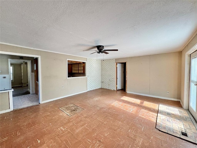 unfurnished room featuring a wealth of natural light, crown molding, ceiling fan, and a textured ceiling