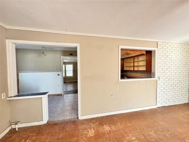 spare room featuring crown molding and a textured ceiling