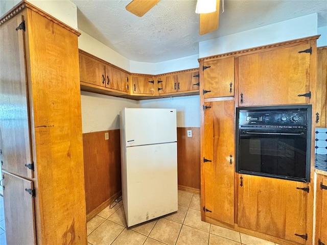 kitchen with oven, ceiling fan, light tile patterned floors, a textured ceiling, and white fridge